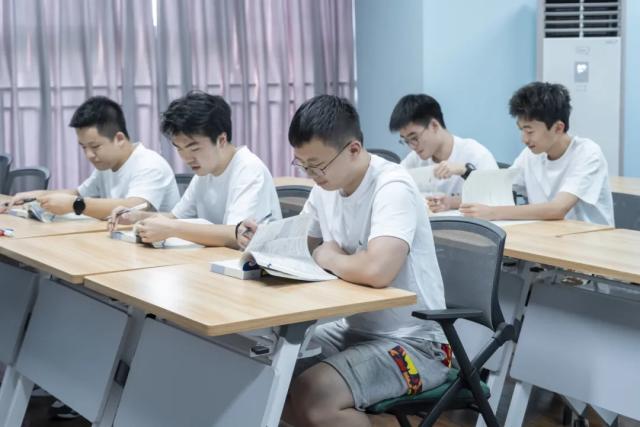 A group of students from Chongqing BI Academy works together on an assignment in a classroom.