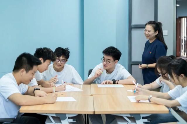 Two students from Chongqing BI Academy collaborate on a project at a table.