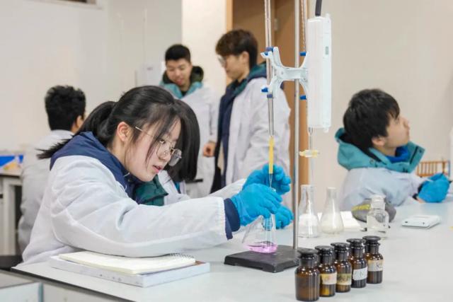 Students from Chongqing BI Academy conduct a chemistry experiment in a lab.