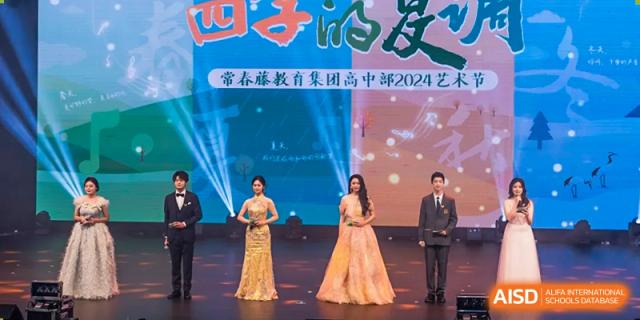 Students from Chongqing BI Academy stand on a stage for a group photo at an event with guests.