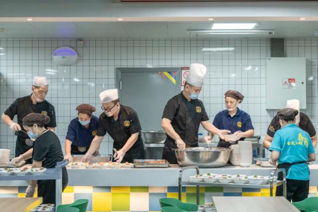 Students and a chef from Chongqing BI Academy prepare food together in a cooking class.