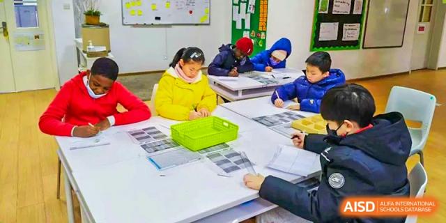 Students from EtonHouse International School Nanjing at a table with a teacher.