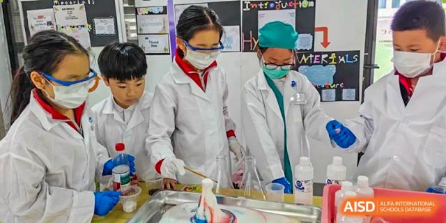 A student from EtonHouse International School Nanjing in a face mask and lab coat, holding a flask.