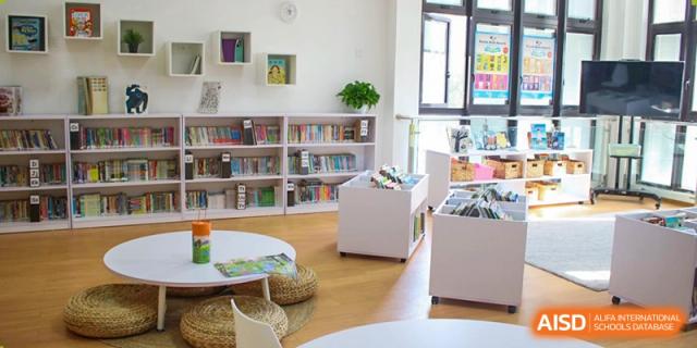 An empty library at EtonHouse International School Nanjing with white shelves.