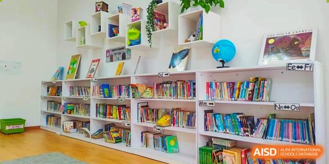 A shelf with various books and objects in the library at EtonHouse International School Nanjing.