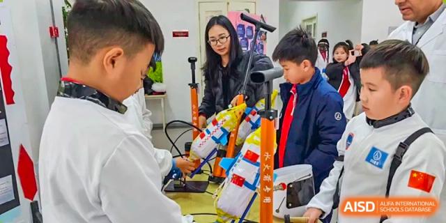 A student from EtonHouse International School Nanjing working on a robotics project with a teacher.