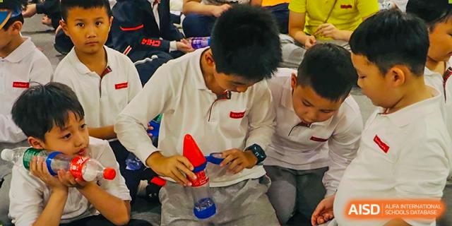 Two students from EtonHouse International School Nanjing working with wires and a small object.