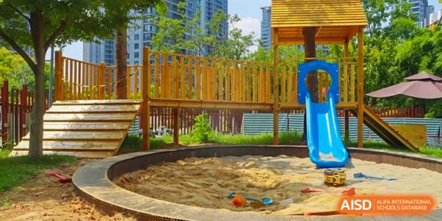A sandpit with small toys in a playground at EtonHouse International School Nanjing.
