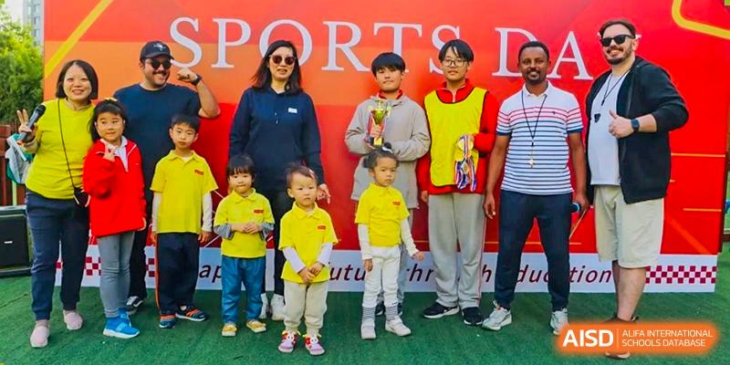 A group of young students from EtonHouse International School Nanjing standing with teachers in a line.