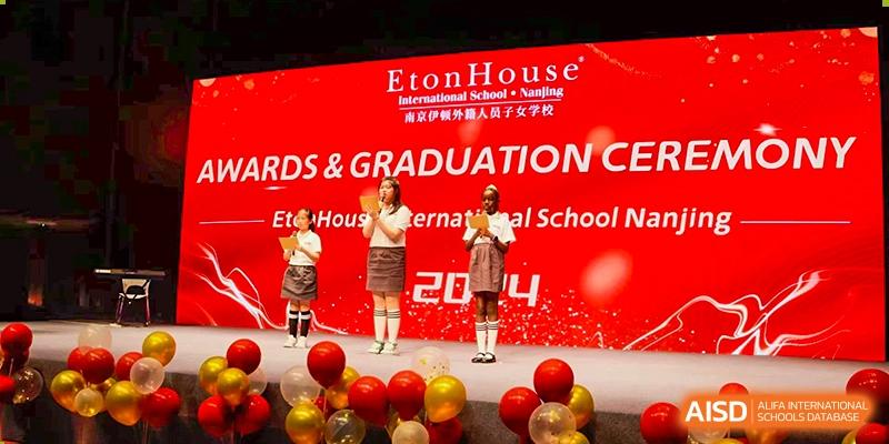 A teacher from EtonHouse International School Nanjing on a stage with a student for a graduation ceremony.