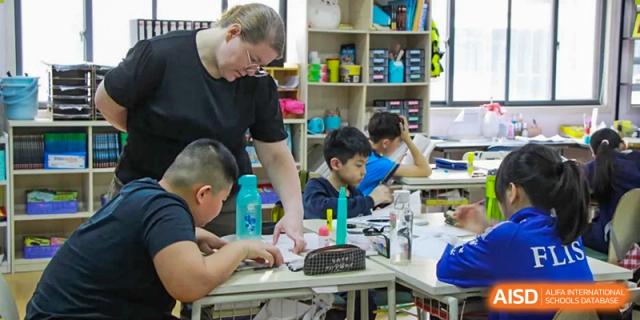 A teacher from EtonHouse International School Nanjing helping students with a hands-on project.