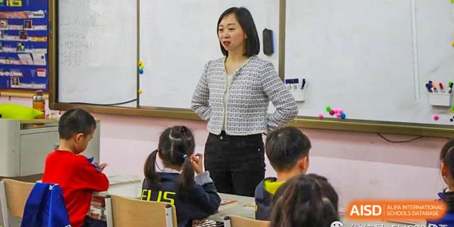 A female teacher from EtonHouse International School Nanjing talking to a group of young students.