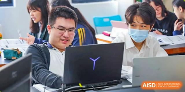 Two students from EtonHouse International School Nanjing working on a laptop together.