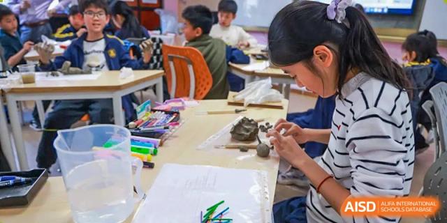 Students from EtonHouse International School Nanjing working on a hands-on project at a table.