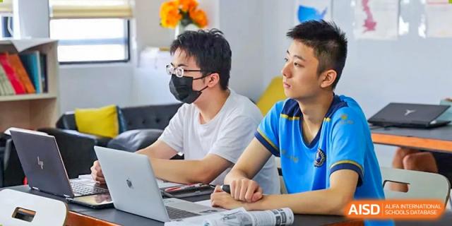Two students from EtonHouse International School Nanjing working on a laptop together.