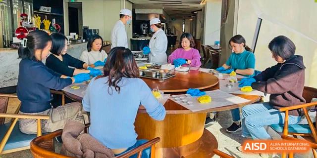 A teacher from EtonHouse International School Nanjing helping a student with a meal.