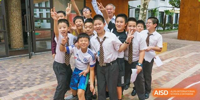 A group of male students from Shanghai Concord Bilingual School smile and pose for a photo together.
