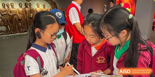 Students from Shanghai Concord Bilingual School are focused on their work, possibly in a classroom or library setting.