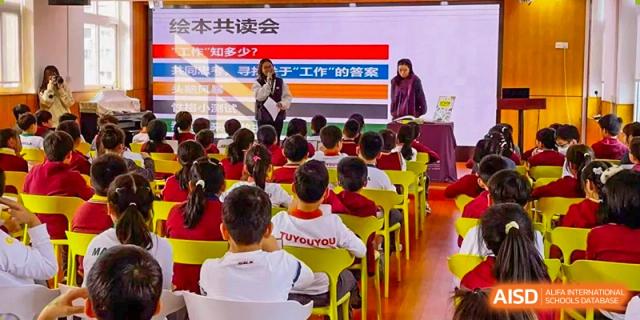 A teacher from Shanghai Concord Bilingual School stands in front of a classroom of young students who are all looking at the screen.