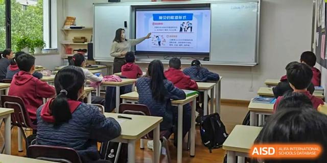 A teacher from Shanghai Concord Bilingual School points to a screen while teaching a class.