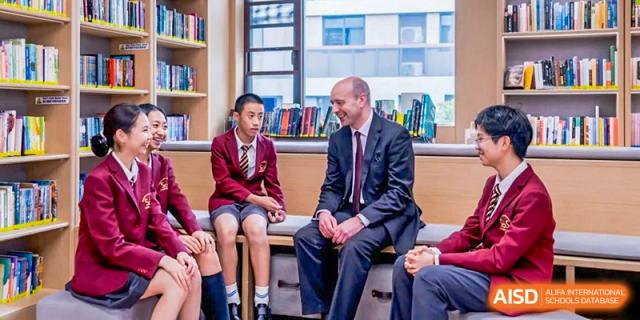 A female student from Shanghai Concord Bilingual School sits and talks with an adult male.