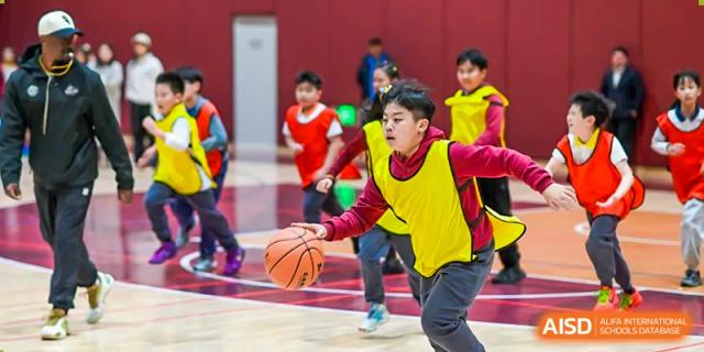 A young student from Shanghai Concord Bilingual School dribbles a basketball during an indoor game.