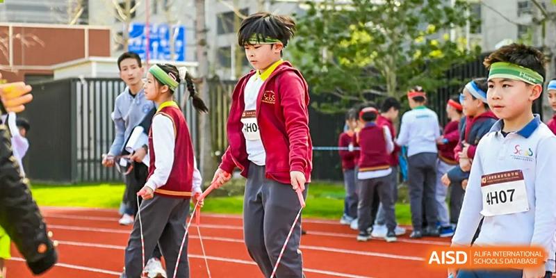 A young male student from Shanghai Concord Bilingual School participates in a skipping rope activity.