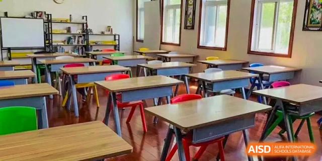 A traditional, empty classroom with student desks and chairs at Wuxi Guanghua School.