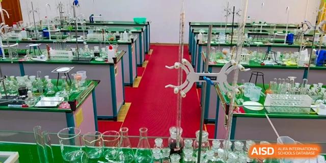 A science lab setup with a titration apparatus and glassware on a red mat at Wuxi Guanghua School.