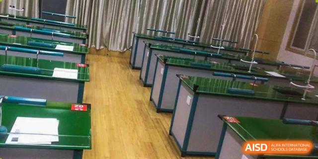 A line of science lab benches with green sinks in a chemistry or physics classroom at Wuxi Guanghua School.