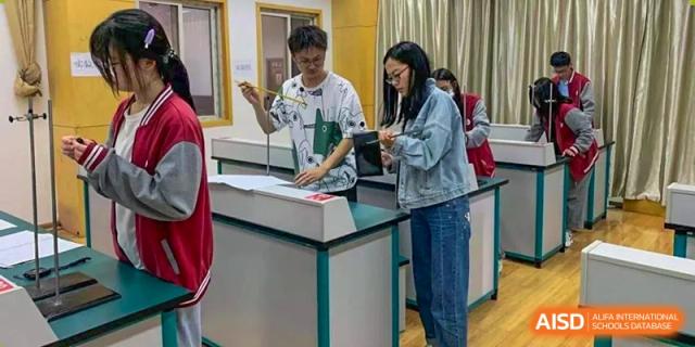 A male and female student collaborating on a science experiment in a laboratory at Wuxi Guanghua School.