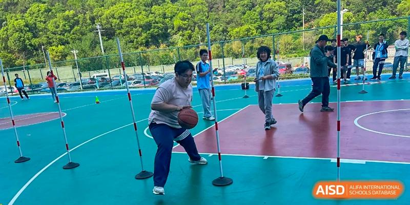 A student practicing basketball skills by dribbling through cones during a physical education or training session at Wuxi Guanghua School.