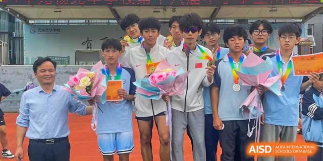 Male students posing with medals and flowers after a sports competition or event at Wuxi Guanghua School.