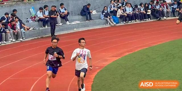 A male student running on the track during a race or practice session at Wuxi Guanghua School.