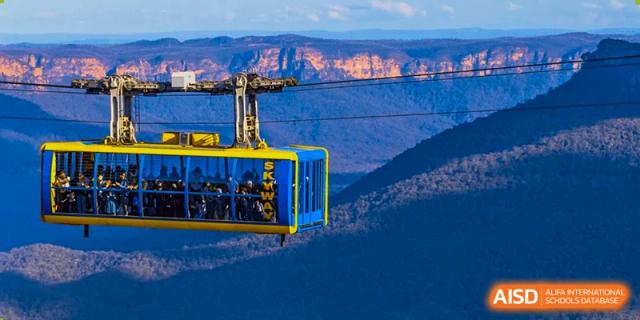 A cable car traveling over mountains, representing an outdoor trip or educational experience for students of Wuxi Guanghua School.