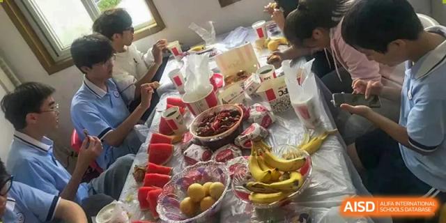 A table laden with fruit and milk, possibly for a meal or nutrition break at Wuxi Guanghua School.