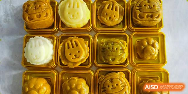 Close-up of mooncakes or pastries with animal faces, possibly for a school festival or holiday celebration at Wuxi Guanghua School.