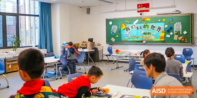 Students from Beijing Lize International Academy sit at tables and read books in a classroom.