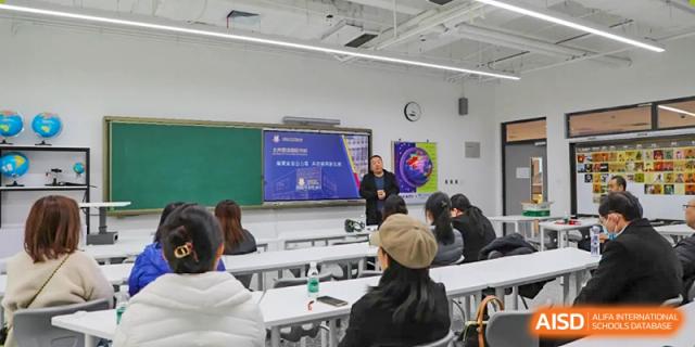 A group of students from Beijing Lize International Academy attends a class with a presentation on a whiteboard.