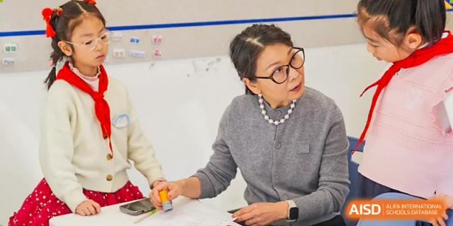 A teacher from Beijing Lize International Academy smiles and shakes hands with a student.