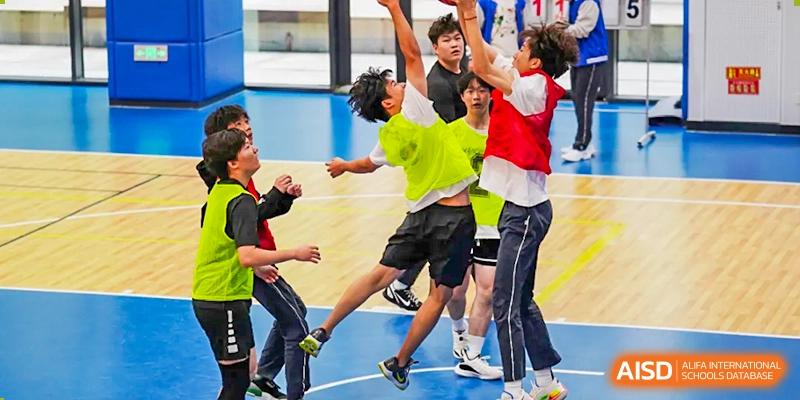 Students from Beijing Lize International Academy in a classroom playing a game that involves punching each other while having fun.