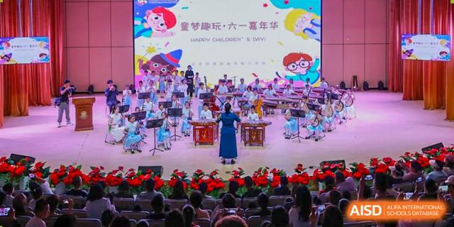A stage performance with students from Beijing Lize International Academy in traditional costumes.