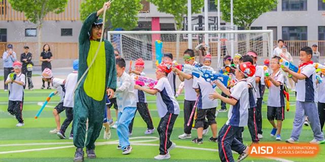 A group of students from Beijing Lize International Academy participates in an outdoor sports activity on a green field.