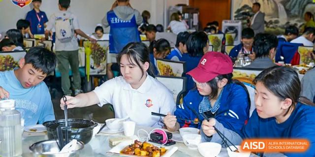 Students from Beijing Lize International Academy wear chef hats and prepare food.