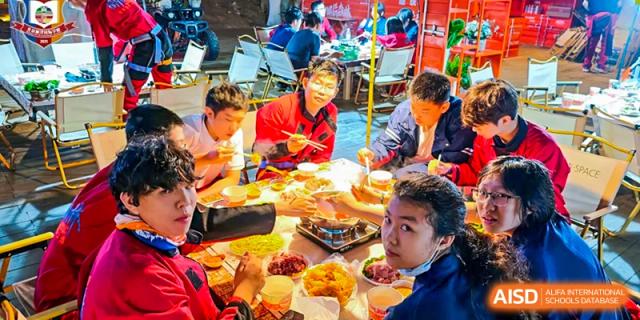 A group of students from Beijing Lize International Academy eats a festive meal.