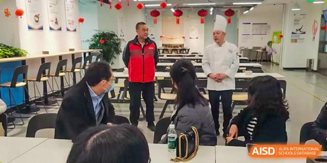 Teachers and students from Beijing Lize International Academy eat and talk at a formal event.