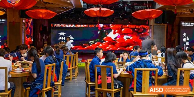 Students and teachers from Beijing Lize International Academy eat dinner in a Chinese restaurant.