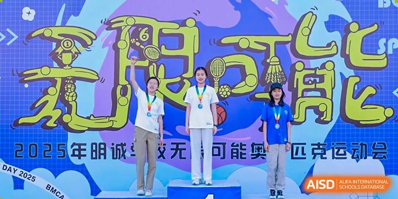 Students receiving medals and awards on a podium at Beijing Mingcheng Academy.