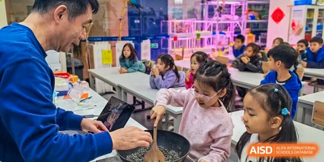 An adult helping a group of young students with a cooking activity at Beijing Mingcheng Academy.