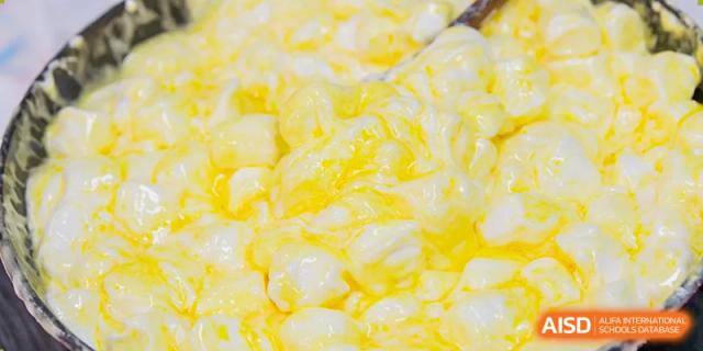 A close-up of a yellow, egg-based dish or ingredient at Beijing Mingcheng Academy.